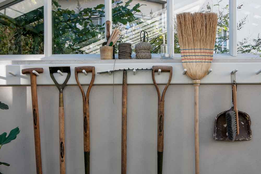 Knoppbräda med verktyg och borstar i växthus.