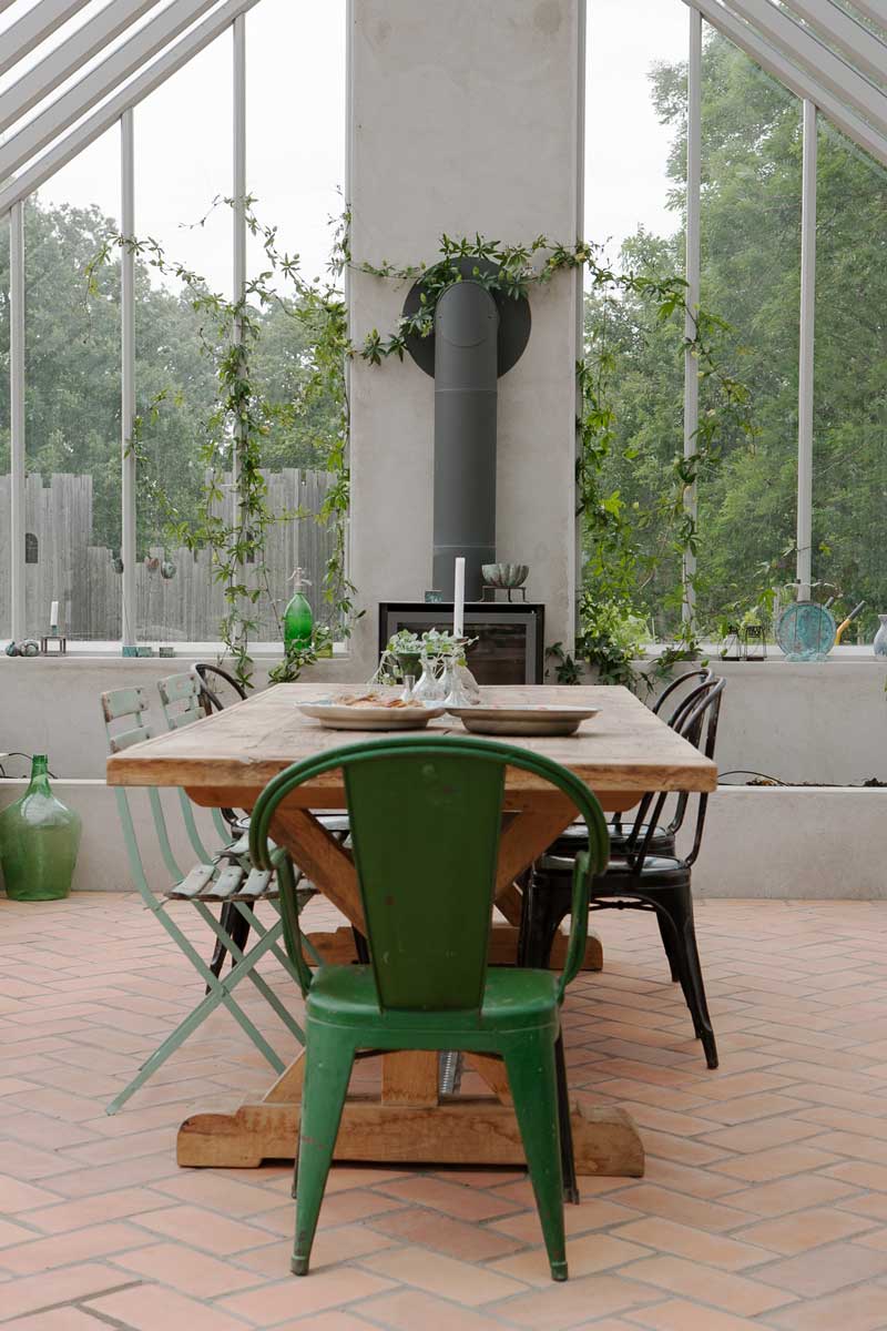 Ett bord och stolar vid kamin i ett växthus