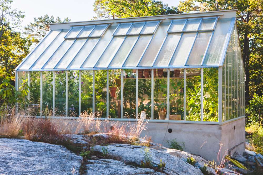 Ett växthus med pulpettak och isolerglas byggt på en terrass.